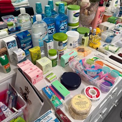 Sale Photo Thumbnail #81: A large assortment of personal care and hygiene products, including mouthwash, lotion, toothpaste, and soap, arranged on a white countertop.