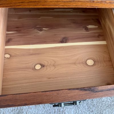 Sale Photo Thumbnail #97: Open wooden drawer featuring a cedar-lined bottom with natural wood grain and knots.