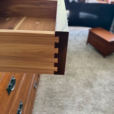 Sale Photo Thumbnail #92: Close-up of a wooden dresser drawer showing dovetail joint construction and a cedar-lined interior.