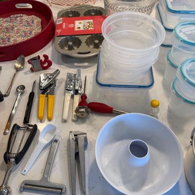 Sale Photo Thumbnail #130: Assorted kitchenware and utensils, including a bundt pan, food storage containers, can openers, and a cheese slicer.