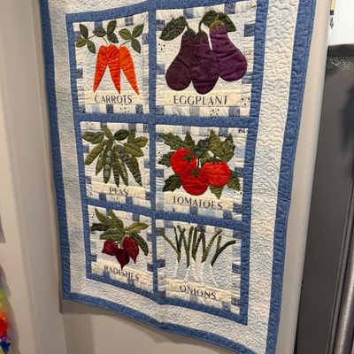 Sale Photo Thumbnail #112: Handmade quilted wall hanging featuring six panels of garden vegetables including carrots, eggplants, peas, tomatoes, radishes, and onions, bordered in blue and white fabrics.