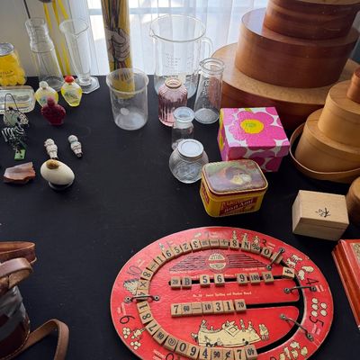 Sale Photo Thumbnail #91: Vintage educational spelling and number board, alongside a collection of glassware, wooden nesting boxes, and small decorative trinkets.