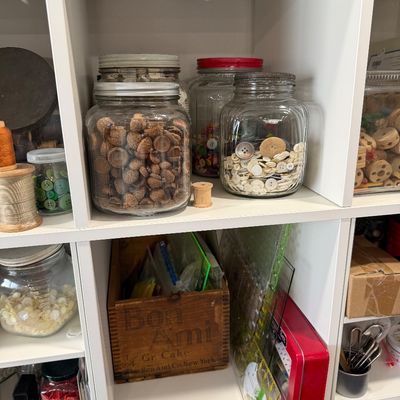 Sale Photo Thumbnail #41: Assorted vintage sewing and craft supplies, including glass jars filled with buttons and acorn caps, wooden spools, and a vintage Bon Ami wooden crate.