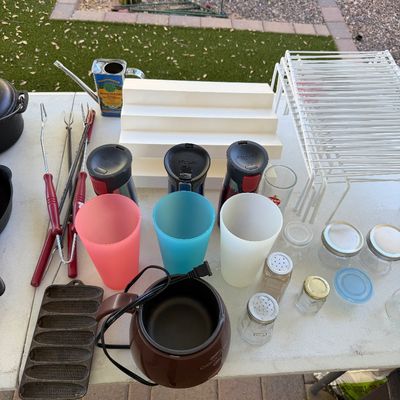 Sale Photo Thumbnail #155: Assorted kitchenware and household items, including Contigo travel mugs, plastic tumblers, a chocolate melting pot, a cast iron cornbread pan, and wire shelving racks.