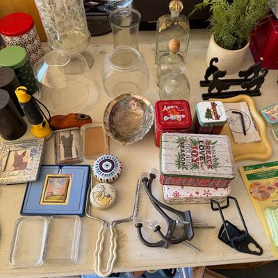 Sale Photo Thumbnail #98: Assortment of vintage and modern home decor, including glass vases, decorative tins, small picture frames, wall hooks, and an abalone shell.