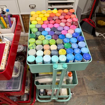Sale Photo Thumbnail #54: Three-tier mint green rolling utility cart filled with a large collection of colorful acrylic craft paint bottles arranged in a rainbow pattern.