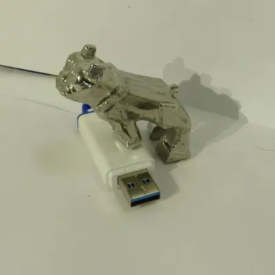 Vintage Mack Trucks chrome bulldog hood ornament, shown next to a USB drive for scale.