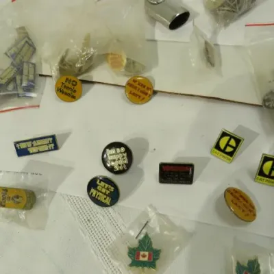 Collection of vintage novelty and advertising pins, including Caterpillar "Cat Power" pins, Canadian maple leaf pins, and...