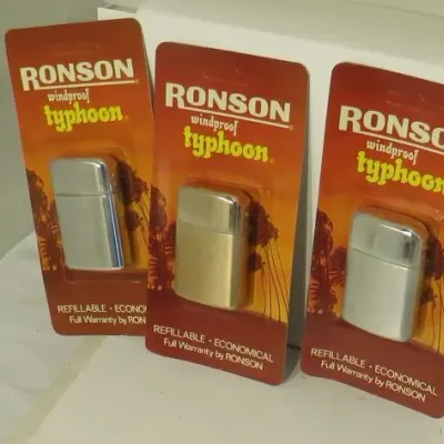 Three vintage Ronson Typhoon windproof lighters, new in their original blister pack packaging.