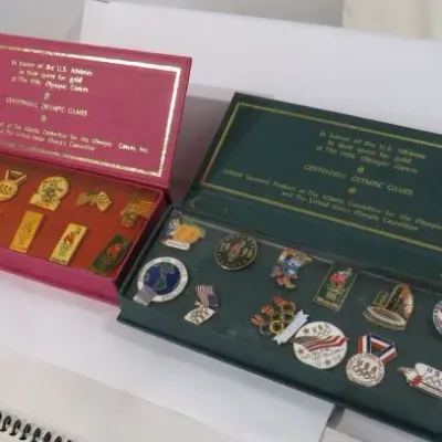 Two boxed sets of commemorative lapel pins from the 1996 Atlanta Centennial Olympic Games, featuring gold-tone and enameled designs in...