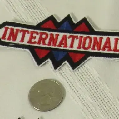 Vintage International Harvester embroidered patch, featuring the classic red, white, and blue triple-diamond logo design.