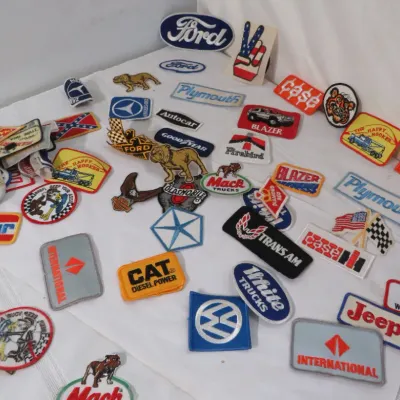 Large collection of vintage embroidered patches featuring automotive, truck, and heavy machinery brands including Ford, Plymouth, Case,...