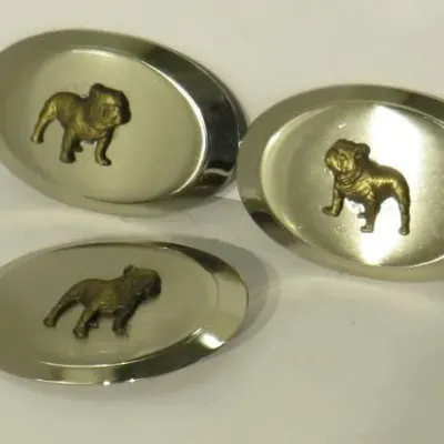 Set of three oval metal belt buckles, each featuring a raised brass-tone bulldog emblem in the center.