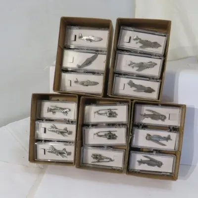 Collection of miniature pewter aircraft models, including various airplanes and helicopters, individually housed in clear plastic display...