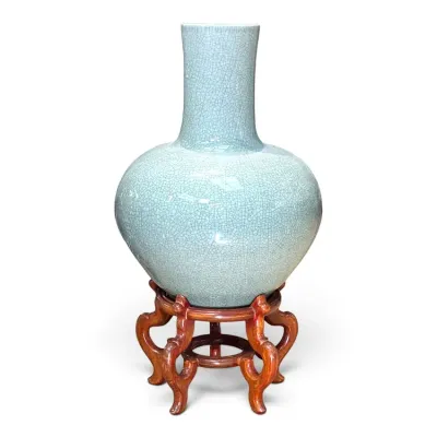 Sale Photo Thumbnail #213: Chinese celadon crackle-glazed porcelain vase, featuring a globular body and tall neck, displayed on an ornate carved wooden stand.