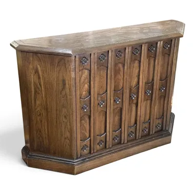Sale Photo Thumbnail #120: Vintage Brutalist-style oak bar cabinet featuring carved geometric panels with floral rosette accents and a canted front design.