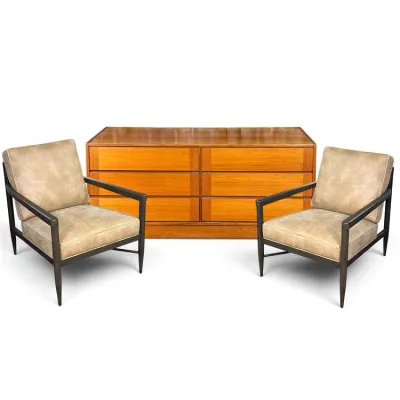 Sale Photo Thumbnail #122: Mid-century modern teak double dresser paired with two dark wood armchairs featuring tan upholstered cushions.