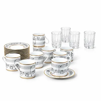Sale Photo Thumbnail #223: Hermès 'Symphonie' porcelain espresso set featuring a musical staff motif with gold trim, accompanied by four cut crystal tumblers.