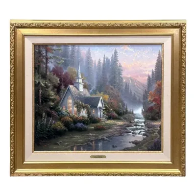 Sale Photo Thumbnail #78: Framed Thomas Kinkade canvas print titled "The Forest Chapel," featuring a glowing church by a stream in a wooded landscape, housed in an ornate gold-finished frame with a linen liner.