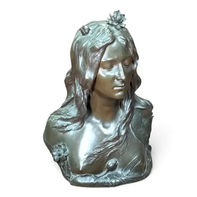 Sale Photo Thumbnail #226: Art Nouveau style bronze bust of a woman with flowing hair and water lily details, featuring a dark brown patina.