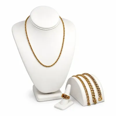 Sale Photo Thumbnail #3: Collection of 14K-18K gold jewelry including a rope chain necklace, three link bracelets, and a statement ring with a brown cabochon stone, displayed on white stands.