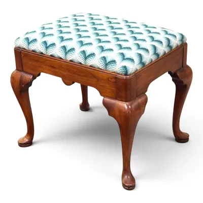 Sale Photo Thumbnail #98: Queen Anne style mahogany footstool featuring cabriole legs with pad feet and a needlepoint upholstered seat in a teal and white geometric pattern.