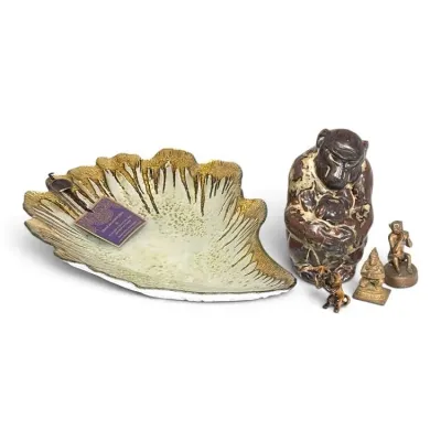 Sale Photo Thumbnail #209: Hand-decorated glass shell-shaped dish with gold trim, shown alongside a collection of small monkey and figure figurines in ceramic and metal.