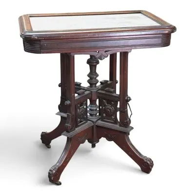 Sale Photo Thumbnail #123: Victorian Eastlake style walnut parlor table featuring an inset white marble top and an ornately carved trestle base on casters.