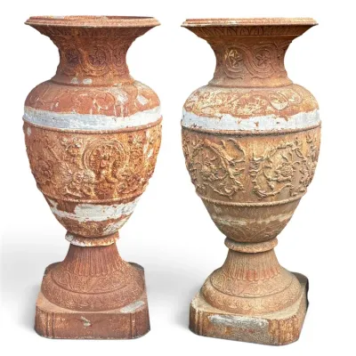 Sale Photo Thumbnail #238: Pair of antique cast iron garden urns featuring ornate neoclassical relief details and a heavily rusted, weathered patina.