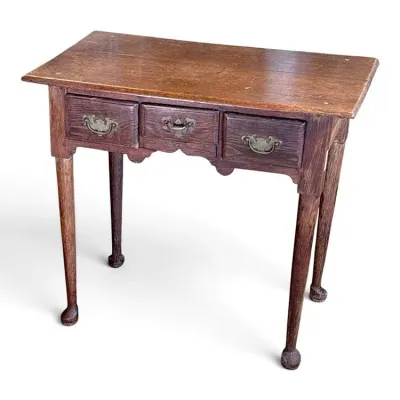 Sale Photo Thumbnail #104: Antique Queen Anne style oak lowboy side table, featuring three drawers with brass batwing pulls, a scalloped apron, and slender cabriole legs ending in pad feet.