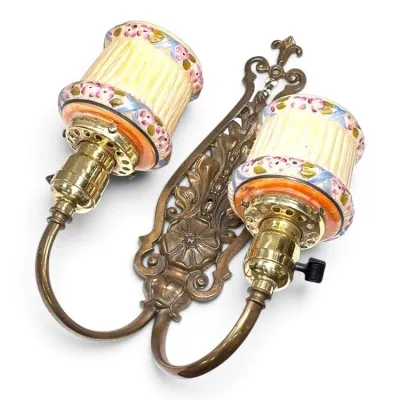 Sale Photo Thumbnail #199: Vintage double-arm brass wall sconce featuring ornate floral detailing and hand-painted ceramic shades with pink floral motifs.