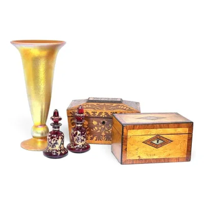 Sale Photo Thumbnail #136: Collection of antique decorative items, including a gold iridescent art glass trumpet vase, a pair of ruby glass scent bottles with gold overlay, and two inlaid wooden boxes.