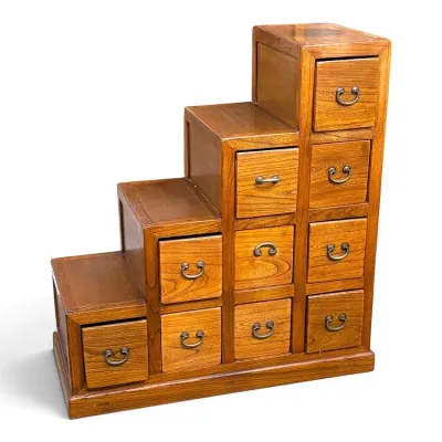 Sale Photo Thumbnail #95: Japanese-style step chest (kaidan tansu) crafted from warm-toned wood, featuring ten drawers with traditional metal drop-pull hardware.