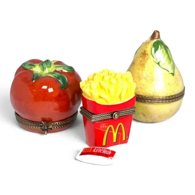 Sale Photo Thumbnail #135: Three porcelain hinged trinket boxes, featuring a red tomato with a bee clasp, a McDonald's french fries container with a miniature ketchup packet accessory, and a yellow pear.