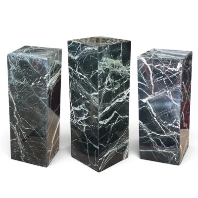 Sale Photo Thumbnail #92: Trio of mid-century modern green marble pedestal columns with heavy white veining, featuring polished surfaces and varying heights.