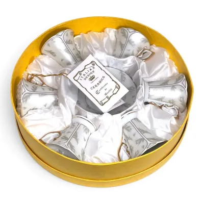 Sale Photo Thumbnail #189: Italian Design Ceramics espresso set featuring six white and silver patterned cups with gold-trimmed handles, nestled in a satin-lined yellow presentation box.