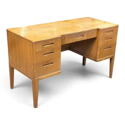 Sale Photo Thumbnail #91: Mid-century modern double-pedestal wooden desk featuring recessed drawer pulls and tapered legs, showing some surface wear.