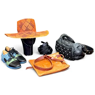 Sale Photo Thumbnail #19: Collection of fashion accessories including an orange woven straw hat, a pair of multi-colored leather oxford shoes, a black studded leather handbag, a tan leather shoulder bag, and a black leather belt.