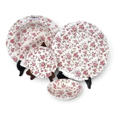 Sale Photo Thumbnail #215: Four-piece vintage ceramic tableware set featuring a delicate pink rose chintz pattern, including plates and bowls displayed on stands.