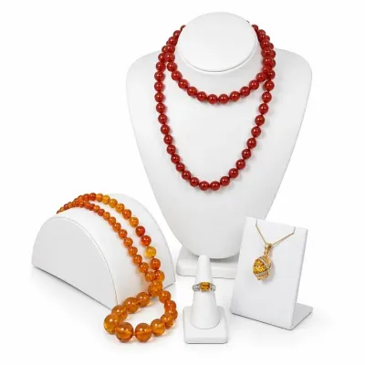 Sale Photo Thumbnail #12: Collection of warm-toned jewelry including a long red carnelian bead necklace, a graduated amber bead necklace, a citrine and diamond ring, and a gold pendant necklace.