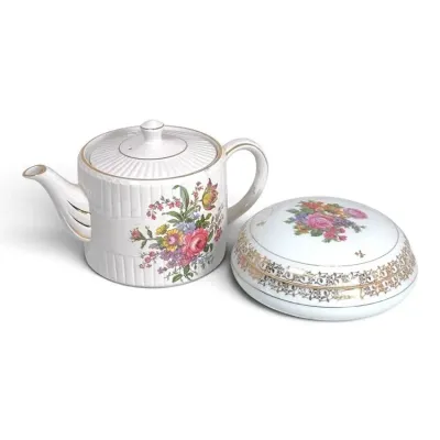 Sale Photo Thumbnail #204: Vintage porcelain teapot with ribbed texture and a matching lidded trinket box, both featuring colorful floral motifs and gold-trimmed accents.