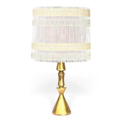 Sale Photo Thumbnail #172: Mid-century modern table lamp featuring a sculptural gold-finished base and a woven drum shade with metallic gold accents.