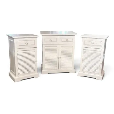 Sale Photo Thumbnail #105: Three-piece cottage-style bedroom storage set in a distressed white finish, featuring a double-door cabinet and two matching single-door nightstands with louvered doors and top drawers.