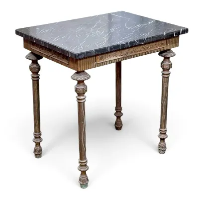 Sale Photo Thumbnail #101: Neoclassical style side table featuring a black marble top with white veining, set on a carved wooden base with fluted details and slender turned legs.