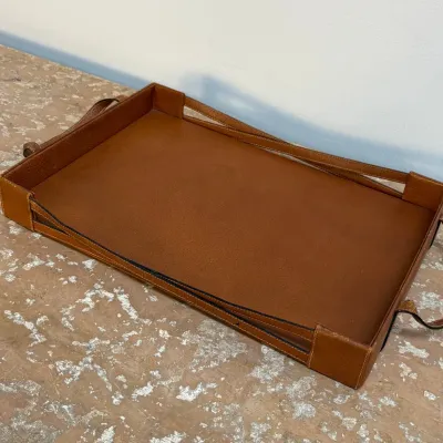 Sale Photo Thumbnail #135: Rectangular brown leather serving tray featuring stitched details and integrated side handles.