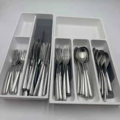 Sale Photo Thumbnail #123: Modern stainless steel flatware set with textured handles, organized in two white plastic drawer trays.
