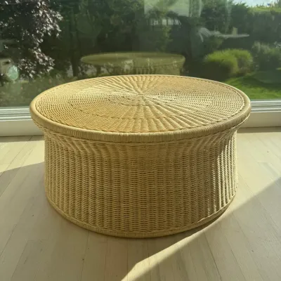 Sale Photo Thumbnail #15: Round woven wicker coffee table or ottoman in a natural finish, featuring a flared top edge and a sunburst pattern on the lid.