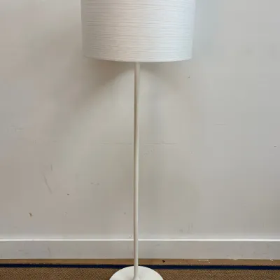 Sale Photo Thumbnail #24: Minimalist white floor lamp with a slender metal stem, tulip-style base, and a textured white drum shade.