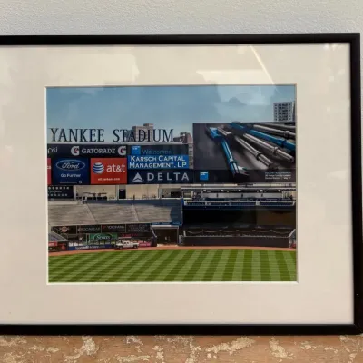 Sale Photo Thumbnail #97: Framed color photograph of Yankee Stadium's outfield and scoreboard, matted in white and set in a simple black frame.