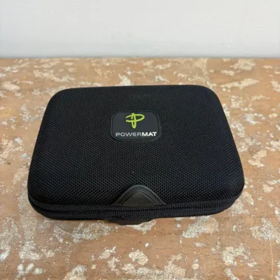 Sale Photo Thumbnail #91: Powermat black zippered hard-shell carrying case with green and white logo, designed for portable wireless charging accessories.